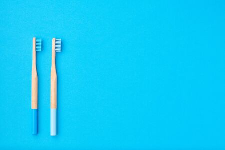 Toothbrushes on blue background top view copy space. Tooth care, dental hygiene and health concept.の写真素材