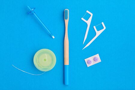 Toothbrush and oral care tools over blue background top view copy space flat lay. Tooth care, dental hygiene and health concept.の写真素材