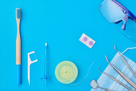 Dentist tools over blue background top view flat lay. Tooth care, dental hygiene and health concept.の写真素材