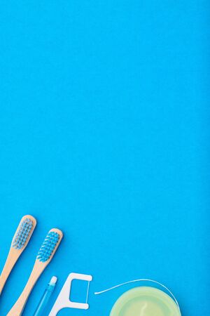Toothbrushes and oral care tools over blue background top view copy space flat lay. Tooth care, dental hygiene and health concept.の写真素材