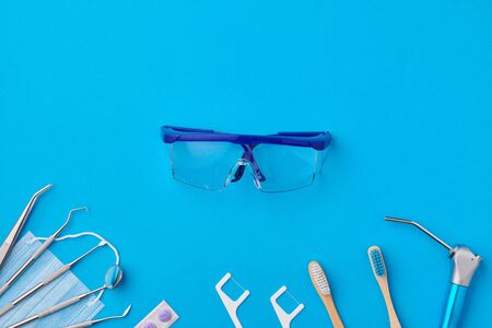 Dentist tools over blue background top view copy space flat lay. Tooth care, dental hygiene and health concept.の写真素材