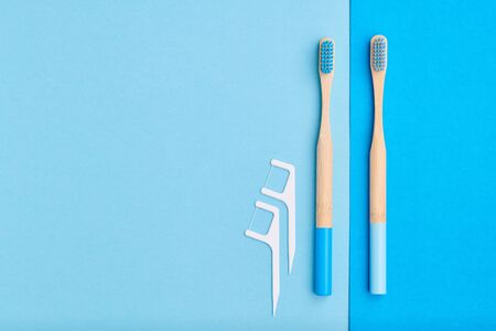 Toothbrushes and oral care tools over blue background top view copy space flat lay. Tooth care, dental hygiene and health concept.の写真素材