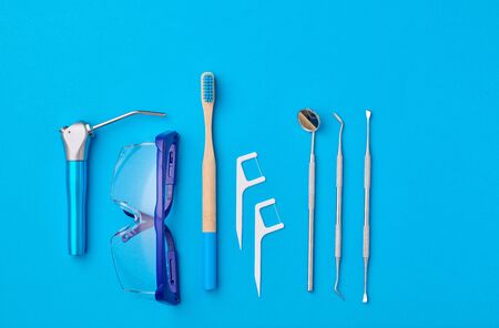 Dentist tools over blue background top view copy space flat lay. Tooth care, dental hygiene and health concept.の写真素材