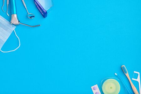 Dentist tools over blue background top view copy space flat lay. Tooth care, dental hygiene and health concept.の写真素材