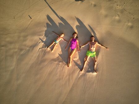 Family lying down on beach aerial top view drone shot at Seychelles, Maheの写真素材