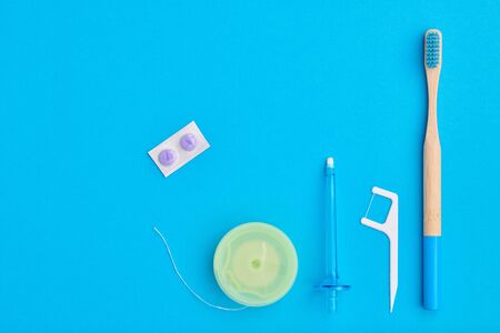 Toothbrushes and oral care tools over blue background top view copy space flat lay. Tooth care, dental hygiene and health concept. の写真素材