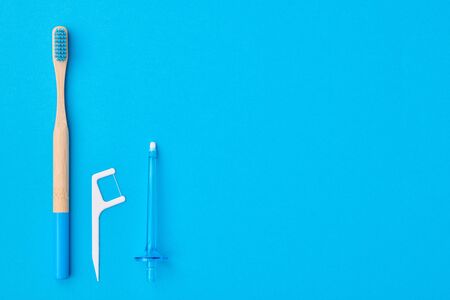 Toothbrushes and oral care tools over blue background top view copy space flat lay. Tooth care, dental hygiene and health concept. の写真素材