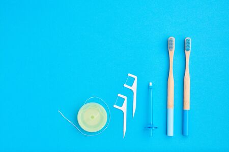 Toothbrushes and oral care tools over blue background top view copy space flat lay. Tooth care, dental hygiene and health concept. の写真素材
