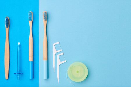 Toothbrushes and oral care tools over blue background top view copy space flat lay. Tooth care, dental hygiene and health concept. の写真素材
