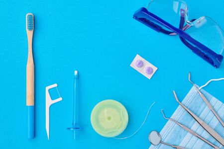 Dentist tools over blue background top view flat lay. Tooth care, dental hygiene and health concept. の写真素材