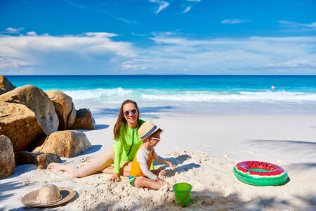 Three year old toddler boy on beach with mother. Summer family vacation at at Seychelles, Mahe.の写真素材