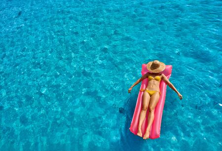 Woman relaxing on inflatable mat float at the beachの写真素材