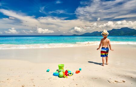 Three year old toddler boy playing with beach toys on beach.の写真素材