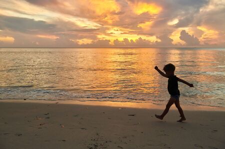 Three year old toddler boy walking on beach at sunset. Summer family vacation at Seychelles, Mahe.の写真素材