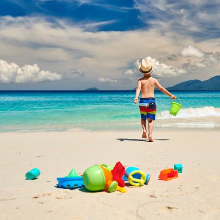 Three year old toddler boy playing with beach toys on beach. Summer family vacation at Seychelles, Mahe.の写真素材