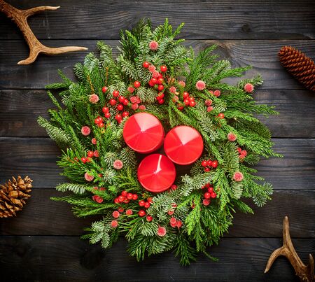 Christmas wreath and candles on dark rustic wooden backgroundの写真素材