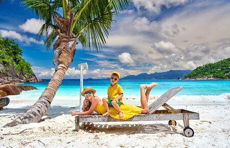 Family on beautiful Petite Anse beach, mother with three year old toddler boy on sun bed. Summer vacation at Seychelles, Mahe.の写真素材