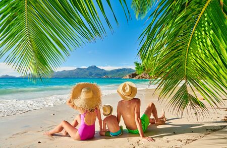 Family on beautiful Anse Soleil beach with palm tree, young couple with three year old toddler boy. Summer vacation at Seychelles, Mahe.の写真素材