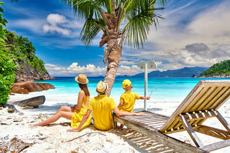 Family on beautiful Petite Anse beach, young couple with three year old toddler boy. Summer vacation at Seychelles, Mahe.の写真素材
