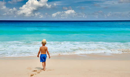 Three year old toddler boy walking on beach. Summer family vacation at Seychelles, Mahe.の写真素材