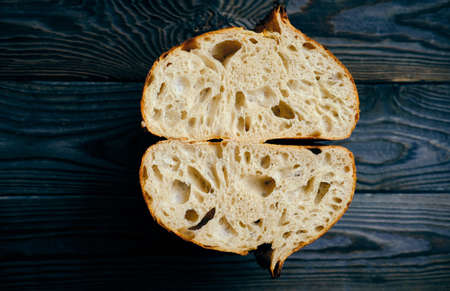 Freshly baked homemade tartine bread on dark wooden tableの写真素材
