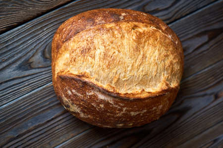 Freshly baked homemade tartine bread on dark wooden table