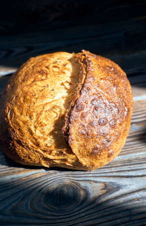 Freshly baked homemade tartine bread on dark wooden table