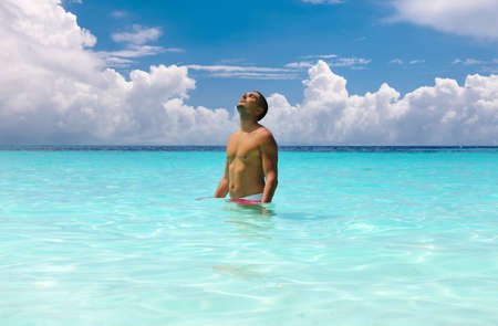 Man in water at tropical beachの写真素材