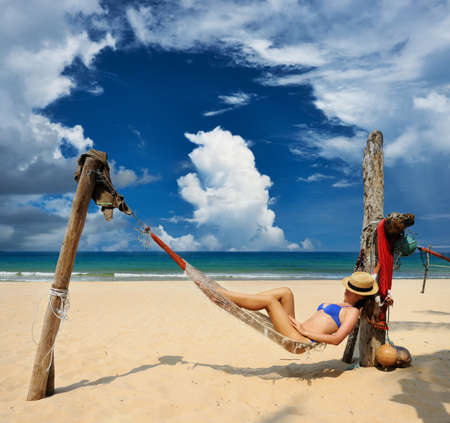 Woman in hammock on tropical beach at Tioman island, Malaysiaの写真素材