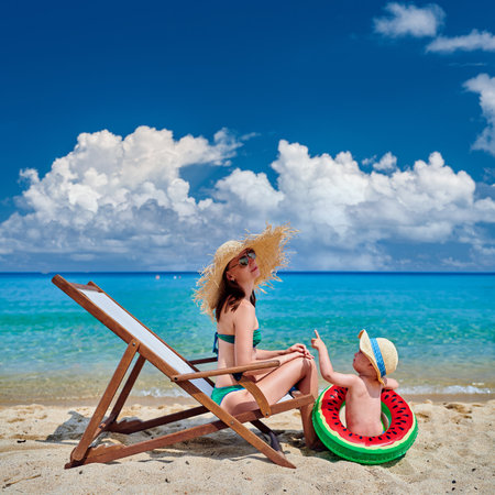 Two year old toddler boy on beach with motherの写真素材