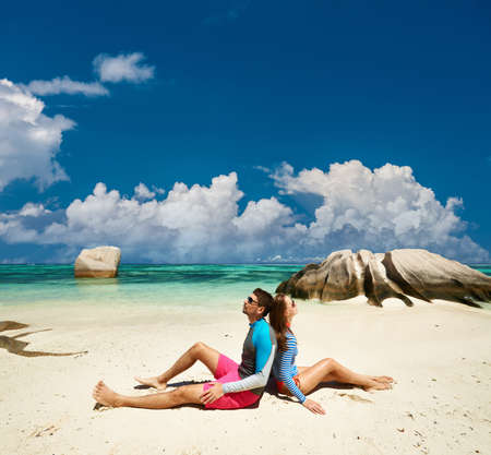 Couple on a tropical beach at Seychelles wearing rash guardの写真素材