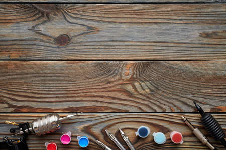 Tattoo machine, tools and supplies over wooden background. Tattoo studio.の写真素材