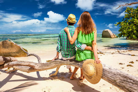 Couple relaxing on a tropical beach Anse Source d'Argent at Seychelles, La Digue.の写真素材