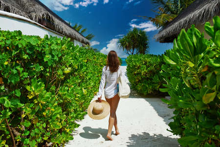 Woman with bag and sun hat going to the beachの写真素材