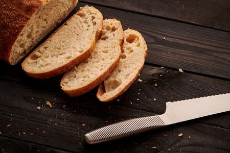 Freshly baked homemade tartine bread on dark wooden tableの写真素材