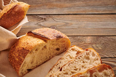 Freshly baked homemade tartine bread on wooden tableの写真素材