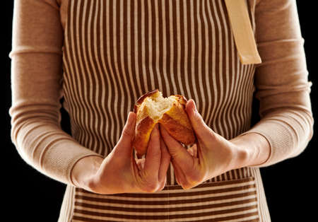 Baker woman holding rustic organic homemade bun in handsの写真素材
