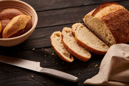 Freshly baked homemade tartine bread on dark wooden tableの写真素材