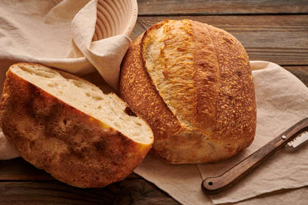 Freshly baked homemade tartine bread on wooden tableの写真素材