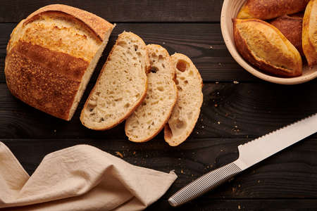 Freshly baked homemade tartine bread on dark wooden tableの写真素材