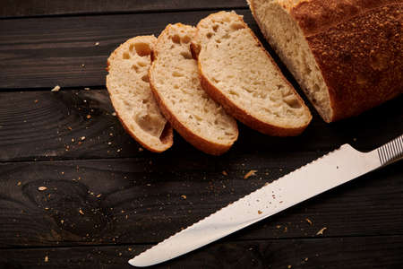 Freshly baked homemade tartine bread on dark wooden tableの写真素材