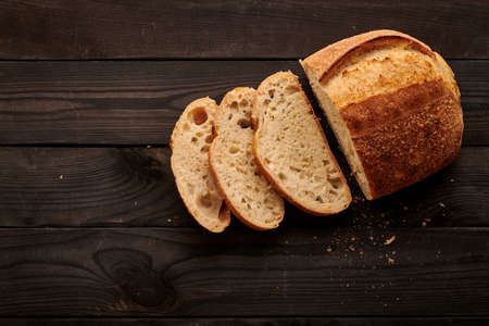 Freshly baked homemade tartine bread on dark wooden tableの写真素材