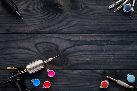 Tattoo machine, tools and supplies over wooden background. Tattoo studio.の写真素材
