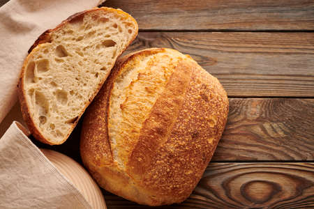 Freshly baked homemade tartine bread on wooden tableの写真素材