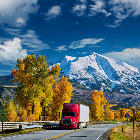Red truck on highway in Colorado at autumn, USA. Mount Sopris landscape.の写真素材