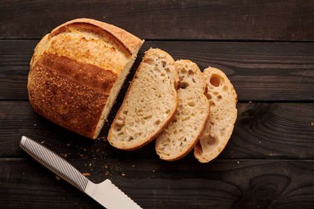 Freshly baked homemade tartine bread on dark wooden tableの写真素材