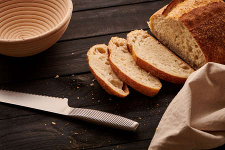Freshly baked homemade tartine bread on dark wooden tableの写真素材