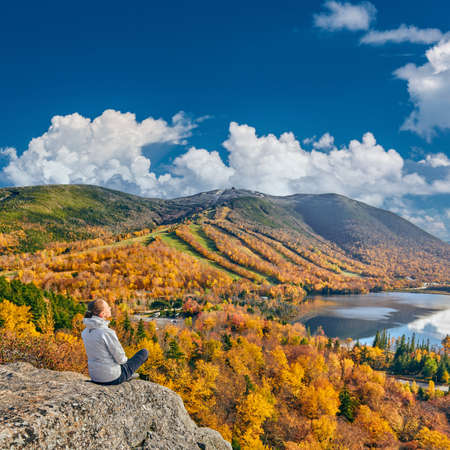 Woman hiking at Artist's Bluff in autumn. View of Echo Lake. Fall colours in Franconia Notch State Park. White Mountain National Forest, New Hampshire, USAの写真素材