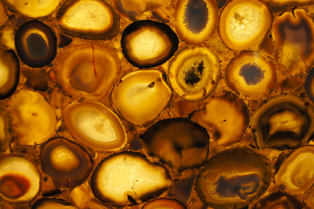 A translucent slice of natural stone agate. Natural patterns and textures of minerals for background. Natural stone agate surfaces, marble, natural rock, mineral stoneの写真素材