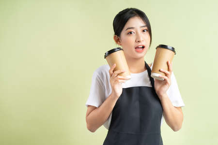 Asian waitress holding two cups of coffeeの写真素材